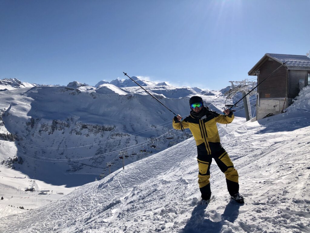 TravelRebel gastblogger gaat skiën in Grand Massif, Frankrijk. Blauwe hemel, skipistes, gele outfit van Peak Performance